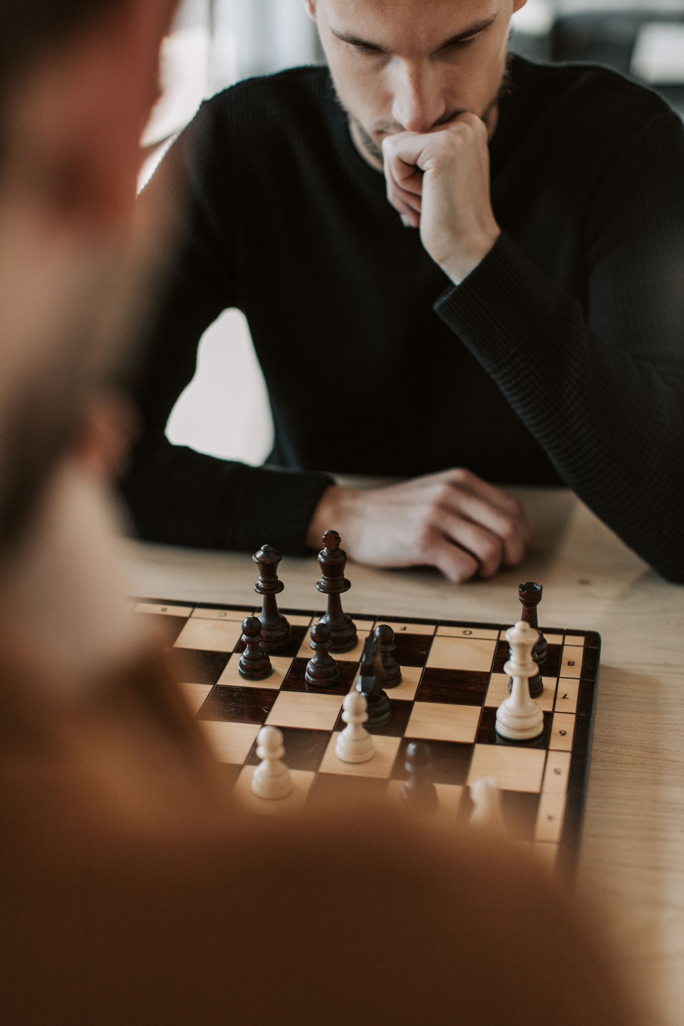 A player leaning over a chessboard in deep concentration
