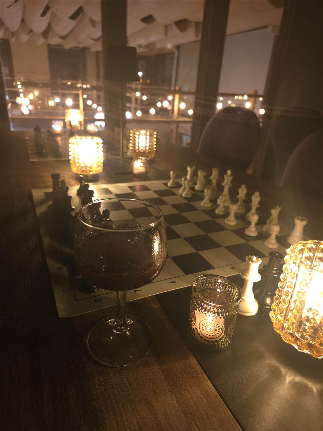 A drink beside a candlelit chessboard at the Carmel Valley Chess Club women's night