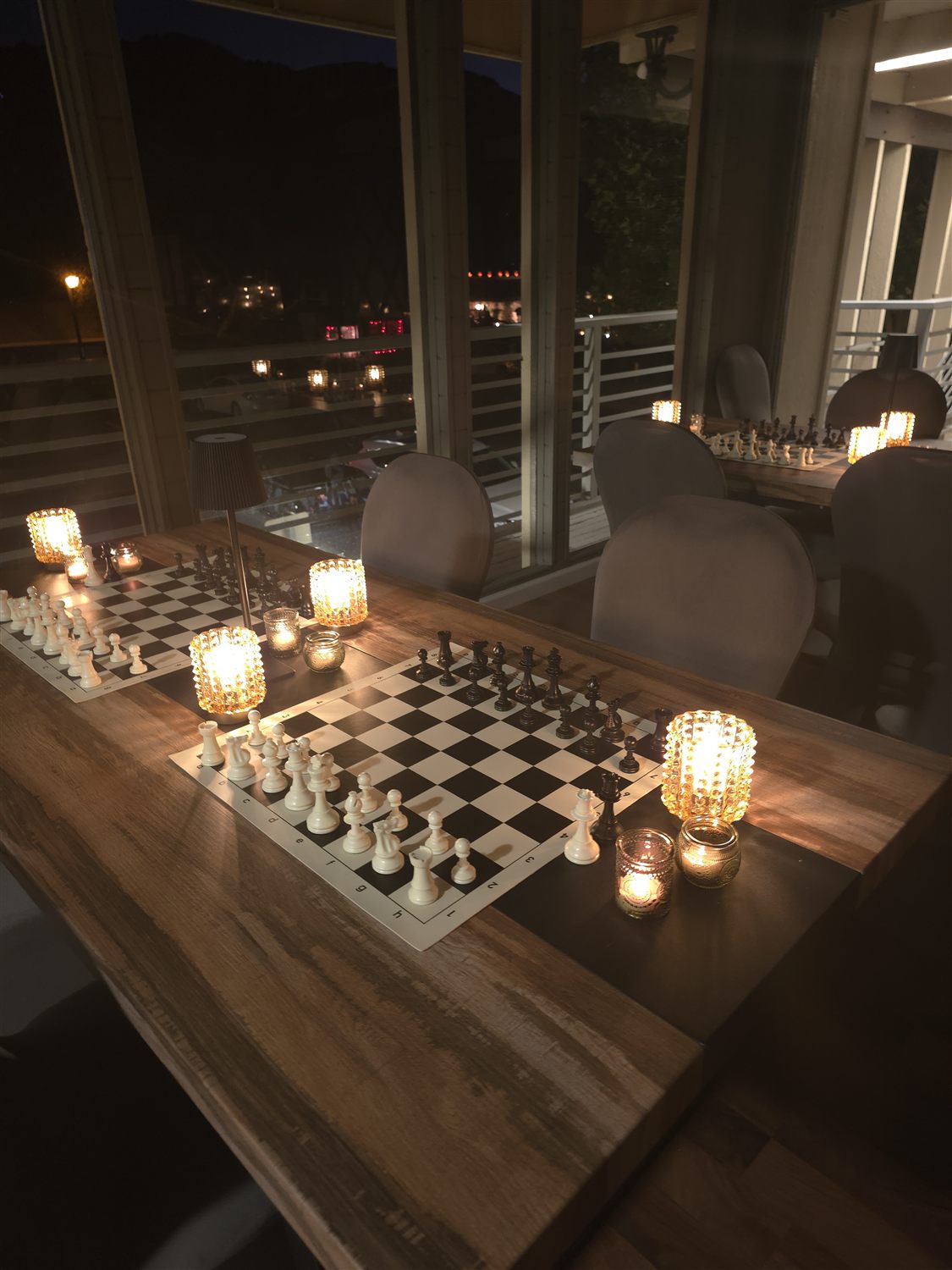 Chessboards set with candles by the window at dusk